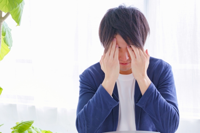 頭をかかえる男性